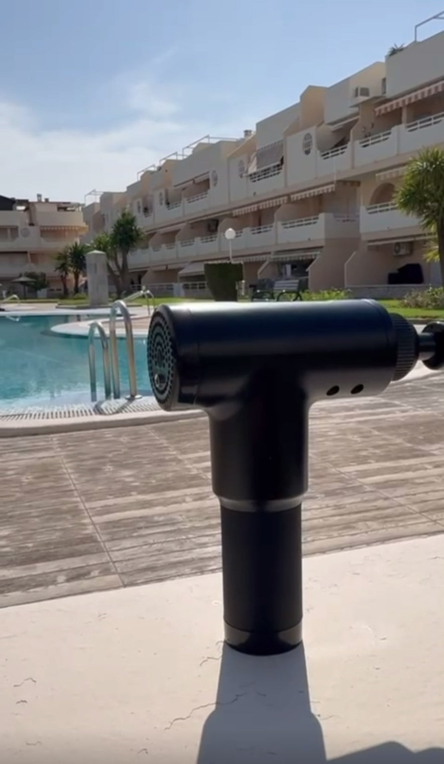 Pistola de masaje muscular portátil con cabezal intercambiable mostrando funcionamiento y uso para aliviar tensión muscular